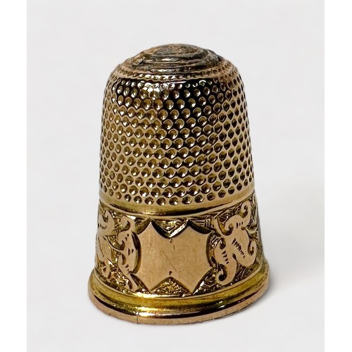 396 - An Edwardian 15ct gold thimble, typical dimled crown and skirt with foliate chased snd ebngraved low... 