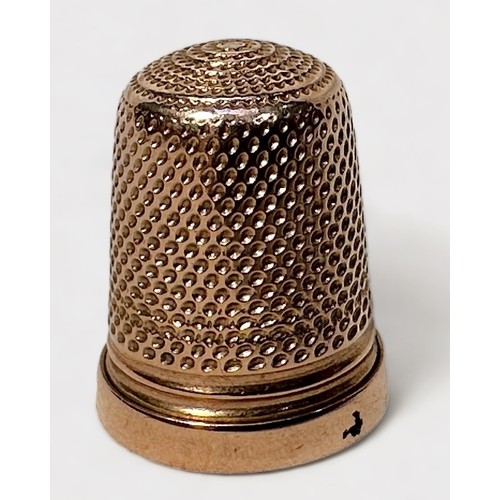 404 - A Late Victorian 9ct gold thimble, of typical dimpled form with harrow horizontal band at the base, ... 