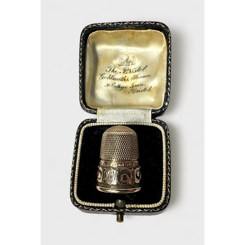 403 - A Victorian 9ct gold thimble, of typical form with dimpled cron and skirt, the lower frieze with a s... 