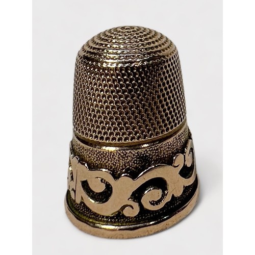 403 - A Victorian 9ct gold thimble, of typical form with dimpled cron and skirt, the lower frieze with a s... 