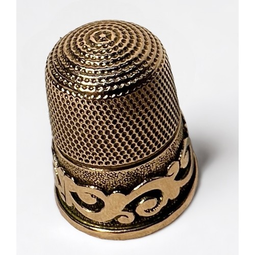 403 - A Victorian 9ct gold thimble, of typical form with dimpled cron and skirt, the lower frieze with a s... 