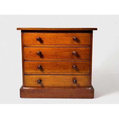 414 - An early 20th century stained walnut table-top collectors chest of four drawers with slide-in glass ... 