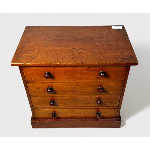 414 - An early 20th century stained walnut table-top collectors chest of four drawers with slide-in glass ... 