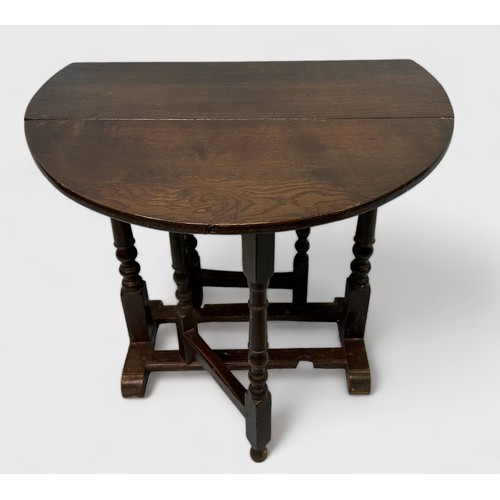 596 - A late 19th/early 20th Century stained oak oval drop-leaf occasional table, gate-leg action base, ra... 