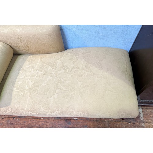 601 - A Victorian-style chaise longue, with cream damask foliate upholstery and matching bolster cushion, ... 