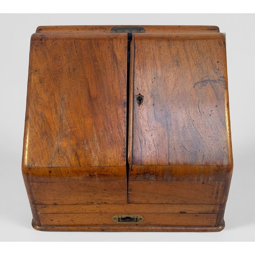 333 - A 19th Century walnut desk tidy/writing comopendium with sloped front and two hinged doors enclosing... 