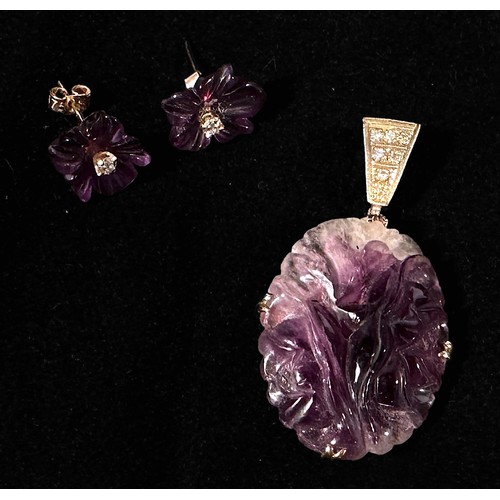 169 - A pair of amethyst and diamond earrings, each carved a five-petal flower, claw-set to the centre wit... 