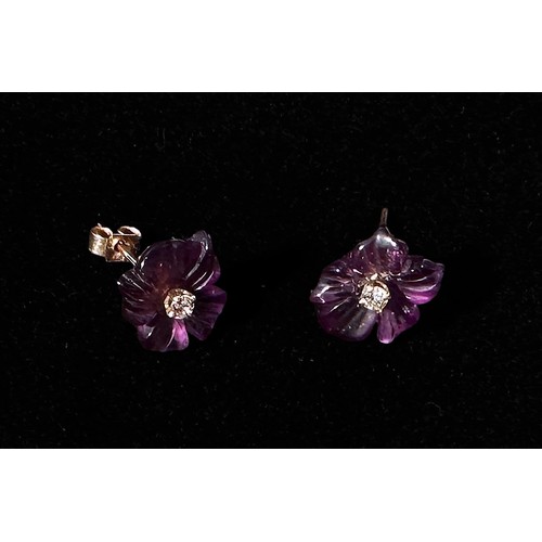 169 - A pair of amethyst and diamond earrings, each carved a five-petal flower, claw-set to the centre wit... 