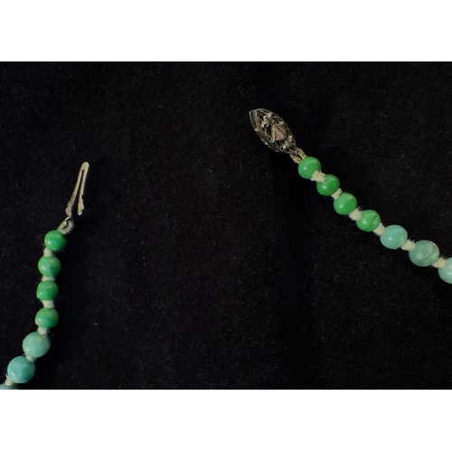 167 - A Chinese graduated Jade bead necklace, individually knotted variegated green beads measuring 6mm to... 