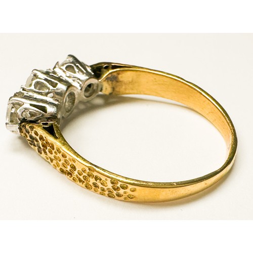 203 - An 18ct yellow gold ring, claw set with three round brilliant cut diamonds, centre stone estimated 0... 