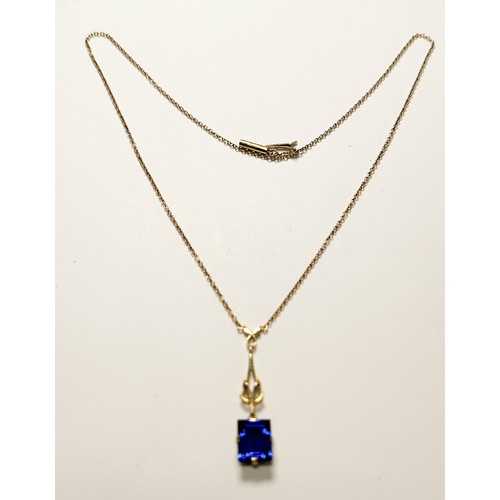 207 - A 9ct yellow gold necklace chain, four-claw set with a rectangular shaped, blue faceted stone, measu... 