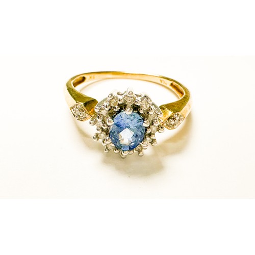 213 - A 9ct yellow gold dress ring, claw set with an oval shaped blue faceted stone to the centre, surroun... 