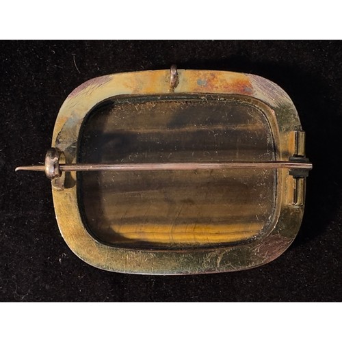 247 - A yellow metal, tests as 9ct gold or above brooch, of rectangular form, set with a rectangular tiger... 