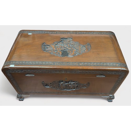 611 - An Oriental carved camphor wood blanket chest, of rectangular form with hinged top, inset carved pan... 