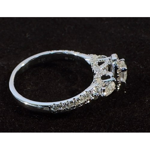 256 - A White Gold and Diamond Ring, centrally four-claw set with an oval faceted diamond with rbc diamond... 