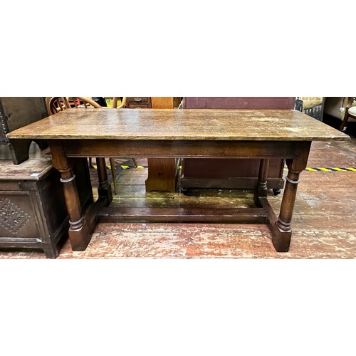 623 - An oak hall/side table, with plank top to plain frieze, raised on turned supports united by stretche... 