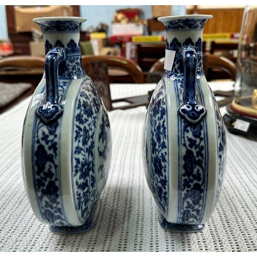 61 - A pair of 20th century Chinese porcelain moon-flasks, of typical form and with blue and white floral... 