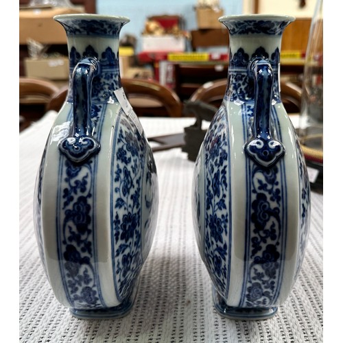 61 - A pair of 20th century Chinese porcelain moon-flasks, of typical form and with blue and white floral... 