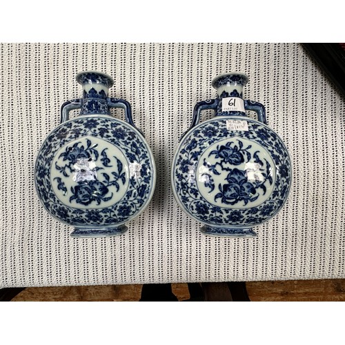 61 - A pair of 20th century Chinese porcelain moon-flasks, of typical form and with blue and white floral... 