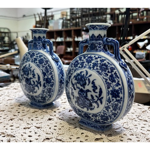 61 - A pair of 20th century Chinese porcelain moon-flasks, of typical form and with blue and white floral... 