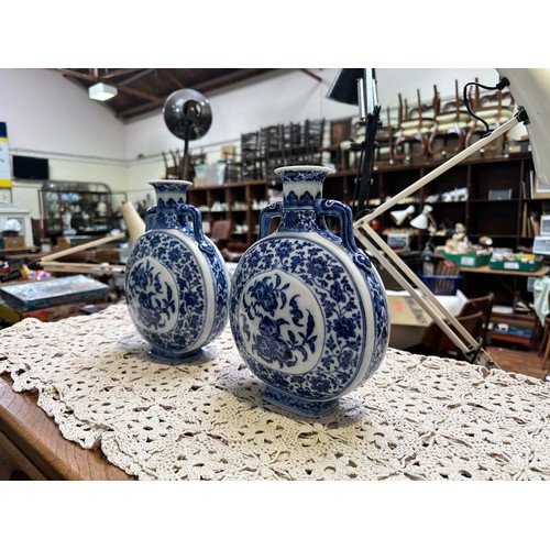 61 - A pair of 20th century Chinese porcelain moon-flasks, of typical form and with blue and white floral... 