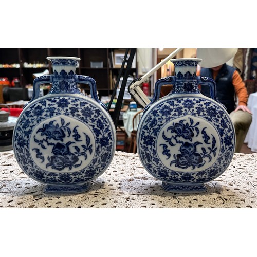 61 - A pair of 20th century Chinese porcelain moon-flasks, of typical form and with blue and white floral... 