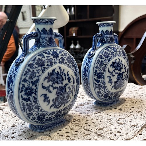 61 - A pair of 20th century Chinese porcelain moon-flasks, of typical form and with blue and white floral... 