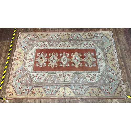 528 - A hand-knotted Caucasian large wool rug, worked in brick-red, yellow, duck egg blue and neutral colo... 