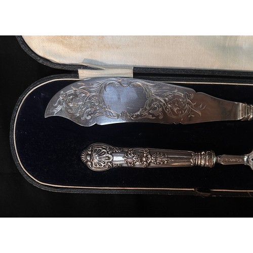 71 - A pair of Victorian silver fish servers with scrolling foliate engraved blades, one side a vacant ca... 