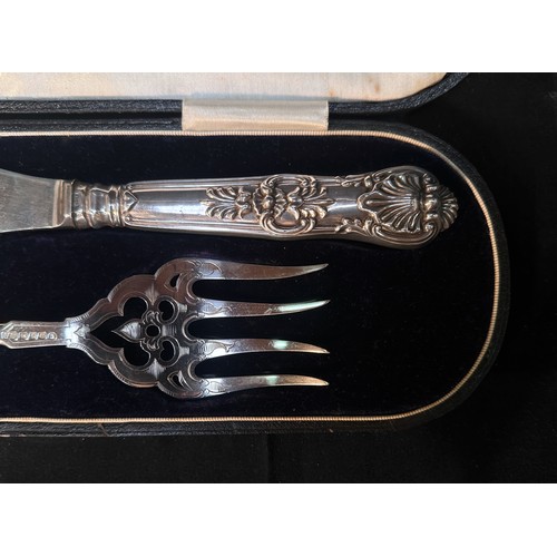 71 - A pair of Victorian silver fish servers with scrolling foliate engraved blades, one side a vacant ca... 