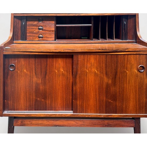 633 - A 1960-70’s rosewood and teak bureau-bookcase with three shelves above a dual-tambor front enclosing... 