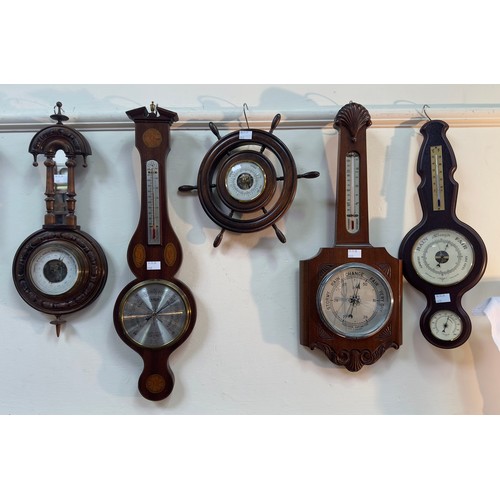 522 - Ten various aneroid barometers, variously mounted on wooden frames including a ships wheels and two ... 