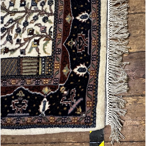 533 - A hand-knotted woollen prayer rug worked with tree of life to a beige central ground within blue bor... 