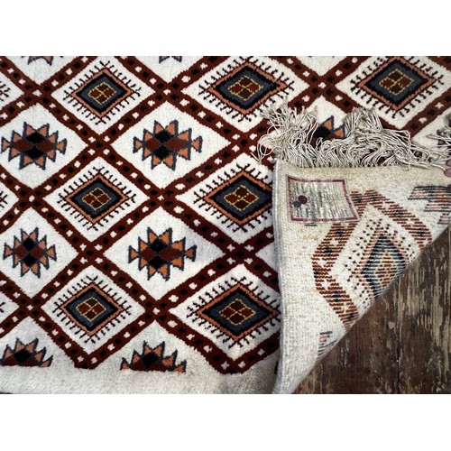 535 - A Caucasian woollen carpet, with a trellis design with stylised guls, and fringed ends, approximatel... 