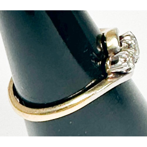 153 - An 18ct yellow gold ring, platinum set with three round diamonds in a twist design, total estimated ... 