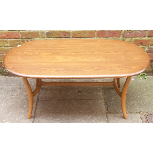 643 - An Ercol elm coffee table, of oval form, raised on downswept supports with stretcher, 115cm long