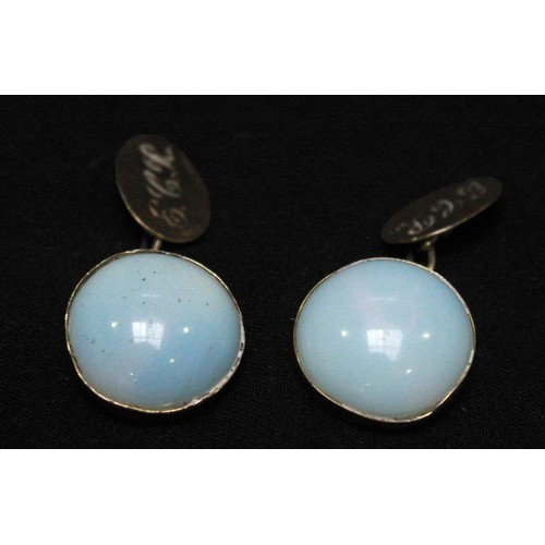 271 - A pair of antique gold and moostone cufflinks, each bezel- set with a large round cabochon moonstone... 