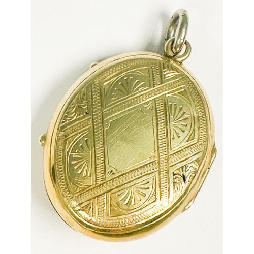 212 - A yellow metal (tests as 9ct or above) oval shaped locket, with diagonal pattern design to the back ... 