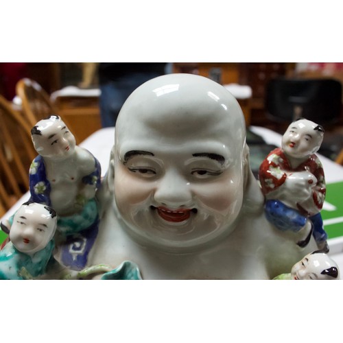 62 - A 20th Century Chinese porcelain figure of a seated laughing Buddha with children, painted in Famill... 