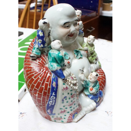 62 - A 20th Century Chinese porcelain figure of a seated laughing Buddha with children, painted in Famill... 