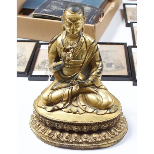 58 - A Gilt-bronze Tibetan style Buddha, seated in lotus position and holding a vajra and meditiation bel... 