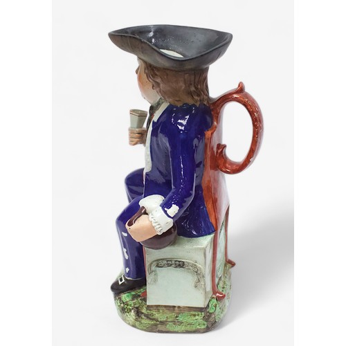 33 - A Prattware ‘Sailor’ toby jug, c1810, with blue frock coat and matching britches, a long tobacco pip... 