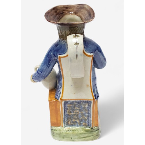 36 - A Prattware Pottery ‘Sailor’ toby jug, c1790-1810, seated holding a jug, striped britches, blue coat... 