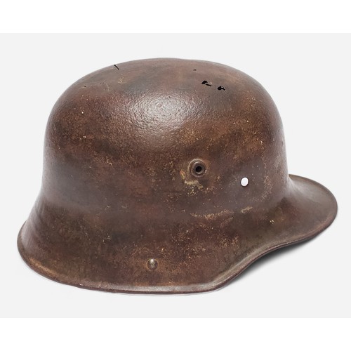 51 - A WWI German M16 Stahlhelm steel combat helmet, lacking liner and chinstrap, splits and holes to she... 