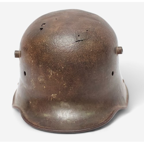 51 - A WWI German M16 Stahlhelm steel combat helmet, lacking liner and chinstrap, splits and holes to she... 