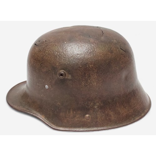 51 - A WWI German M16 Stahlhelm steel combat helmet, lacking liner and chinstrap, splits and holes to she... 