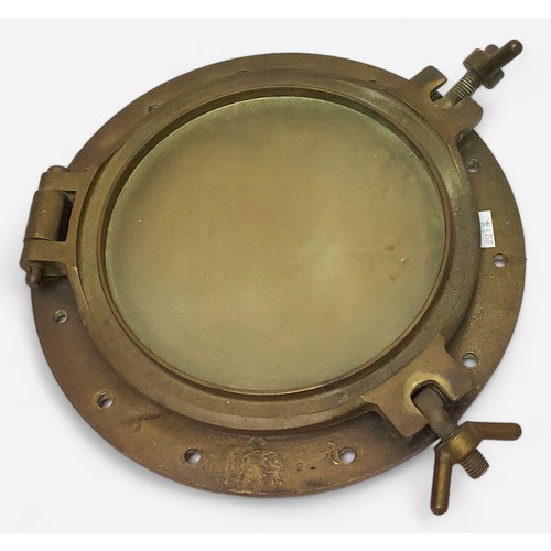 19 - An antique brass ship’s porthole, with lockable, circular, hinged window, backplate measures 38cm di... 