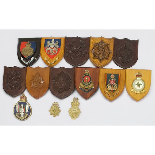 85 - Approximately thirty various military crests, mounted and carved on wooden plaques, including The Ro... 