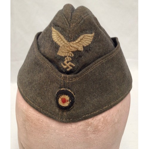 296 - A German WWII Third Reich Luftwaffe side cap, together with a reproduction German WWII Third Reich L... 