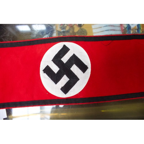 264 - A WWII German Third Reich Swastika pennant, together with an armband, another felt armband and flag.... 